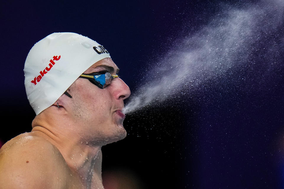 Arkadios Aspougalis of Greece sprays water as he prepares to compete in the mixed 4x100m medley heat at the World Aquatics Championships in Doha, Qatar, Wednesday, Feb. 14, 2024. (AP Photo/Hassan Ammar)