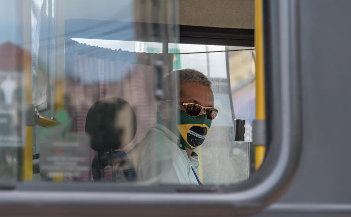 Recife downtown, Pernambuco, Brazil - June 11, 2020:Bus driver working with a brazilian flag themed mask due to Covid- 19.