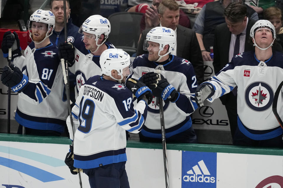 Winnipeg Jets center David Gustafsson (19) celebrates with the bench after scoring in the second period of an NHL hockey game against the Dallas Stars in Dallas, Thursday, April 11, 2024. (AP Photo/Tony Gutierrez)