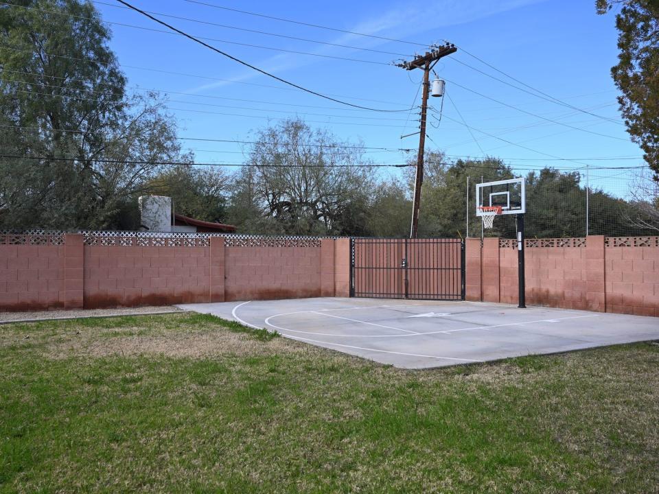 A backyard with a basketball court.