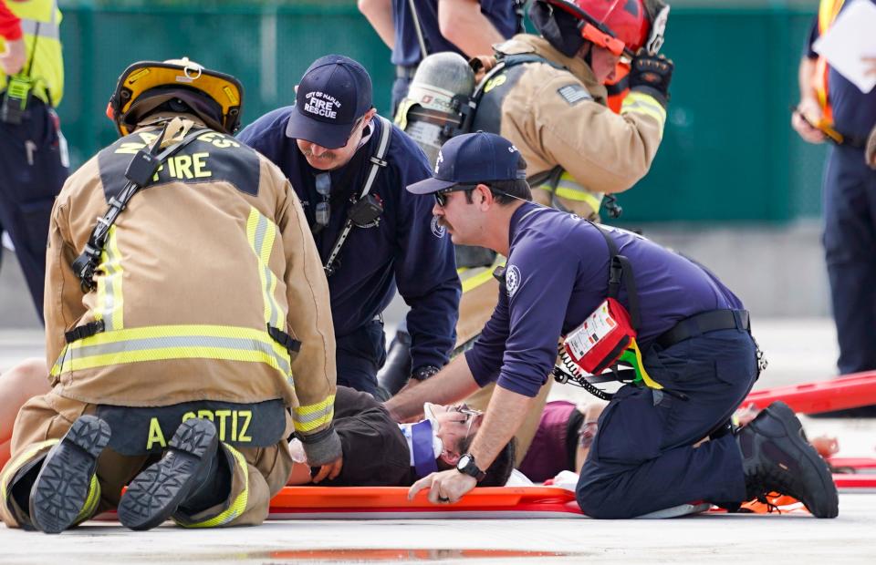 First responders treat students from the Lorenzo Walker Technical College Cosmetology program during a simulated disaster exercise at Naples Airport on Tuesday, April 25, 2023. The students represent injured people after an airplane-related incident.