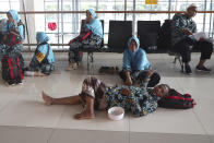 Indonesian who are scheduled to travel to Saudi Arabia for a minor pilgrimage, called 'Umrah', rest at a waiting area as they are turned away from their flights at Soekarno-Hatta International Airport in Tangerang, Indonesia, Thursday, Feb. 27, 2020. Saudi Arabia on Thursday banned foreign pilgrims from entering the kingdom to visit Islam's holiest sites over the new coronavirus, potentially disrupting the plans of millions of faithful ahead of the Muslim fasting month of Ramadan and as the annual hajj pilgrimage looms. (AP Photo/Tatan Syuflana)