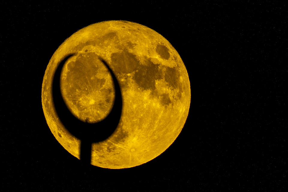 The supermoon rises behind a minaret of a mosque in Beirut, Lebanon, Tuesday, Aug. 1, 2023. The moon appears slightly brighter and bigger than normal because it is closer than usual, just 357,530 kilometers (222,159 miles) away, thus the supermoon label. (AP Photo/Hassan Ammar)