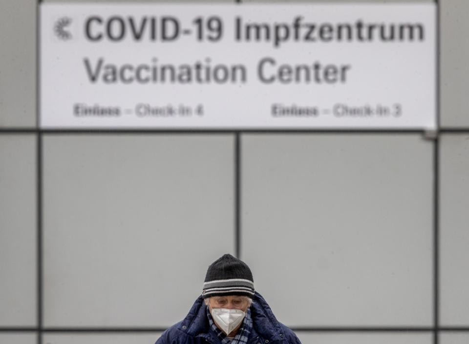 A man wears a face mask as he comes back from the vaccination center in Frankfurt, Germany, Thursday, Jan. 28, 2021. (AP Photo/Michael Probst)