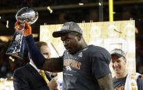 Game MVP Von Miller holds the Lombardi Trophy as Denver Broncos' quarterback Peyton Manning smiles behind him after the Broncos defeated the Carolina Panthers in the NFL's Super Bowl 50 in Santa Clara, California February 7, 2016. REUTERS/Stephen Lam