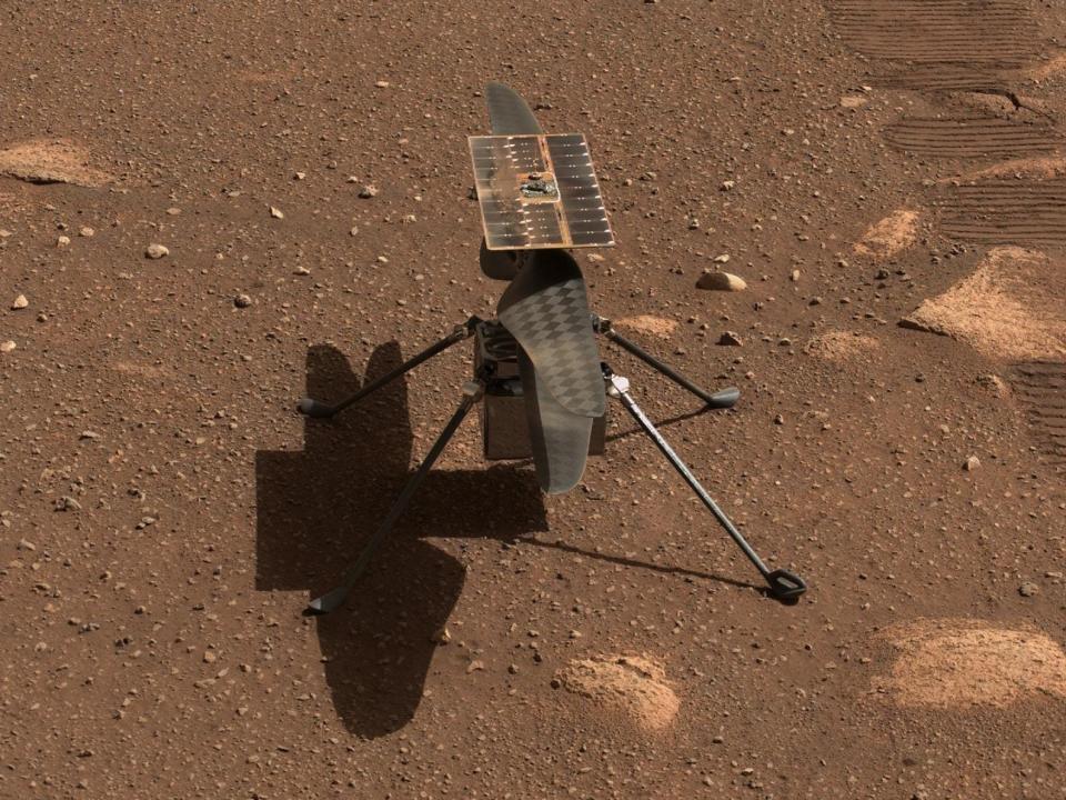 ingenuity drone with helictoper rotors sits on four legs on mars brown dirt