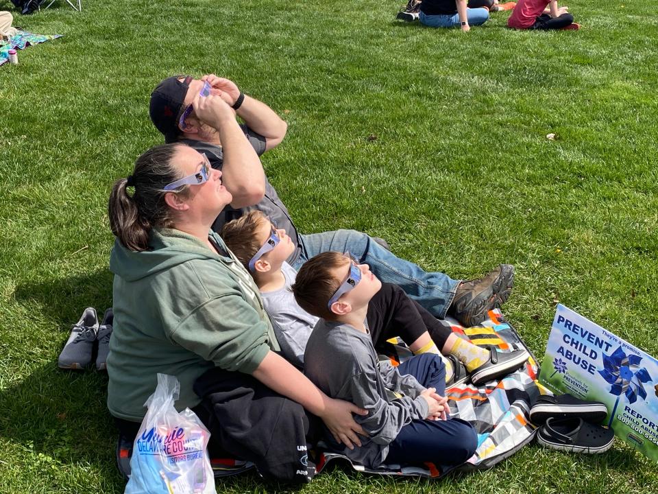 A family from Lowell, Indiana, in Lake County — Gene and Celena Wojciechowski and their sons, Christopher and Gene — spent Sunday night in Muncie to view Monday's total solar eclipse from Canan Commons.