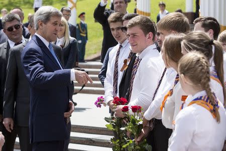 U.S. Secretary of State John Kerry speaks with Russian youths after a wreath laying ceremony at the Zakovkzalny War Memorial in Sochi, Russia May 12, 2015. REUTERS/Joshua Roberts