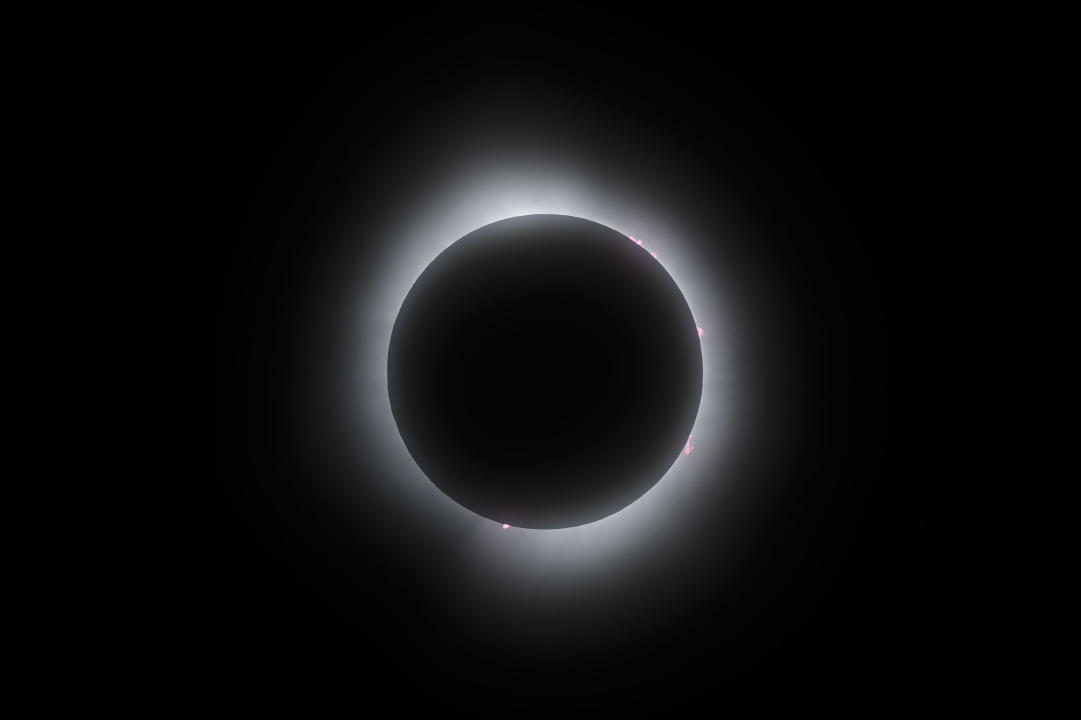 Solar flares fringe the moon as it passes in front of the sun during the totality phase of a total solar eclipse, in Kingston, Ont., Monday, April 8, 2024. THE CANADIAN PRESS/Justin Tang