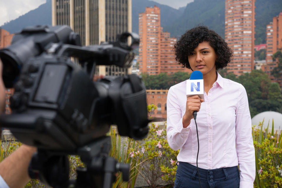 a journalist standing outside in front of a camera