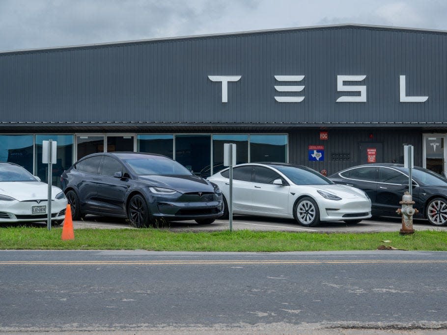 Tesla vehicles sitting on the lot at a Tesla dealership.