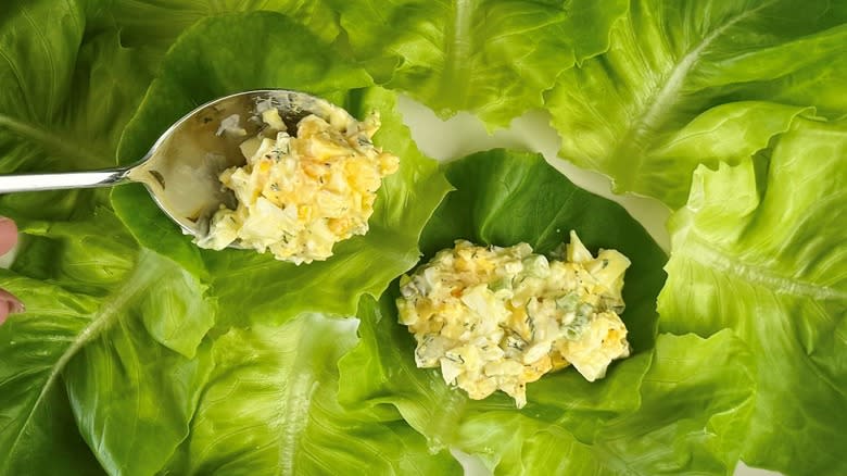 spooning egg salad onto lettuce