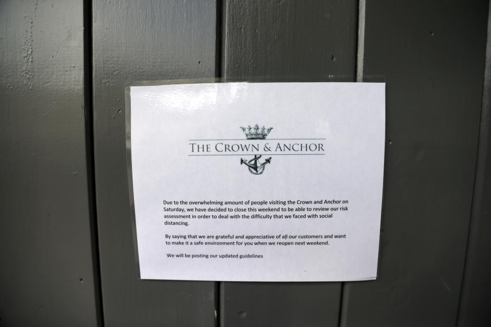 A notice is displayed outside the Crown and Anchor pub following a spike in cases of the coronavirus disease (COVID-19) to visitors of the pub in Stone, Britain, July 29, 2020. REUTERS/Carl Recine