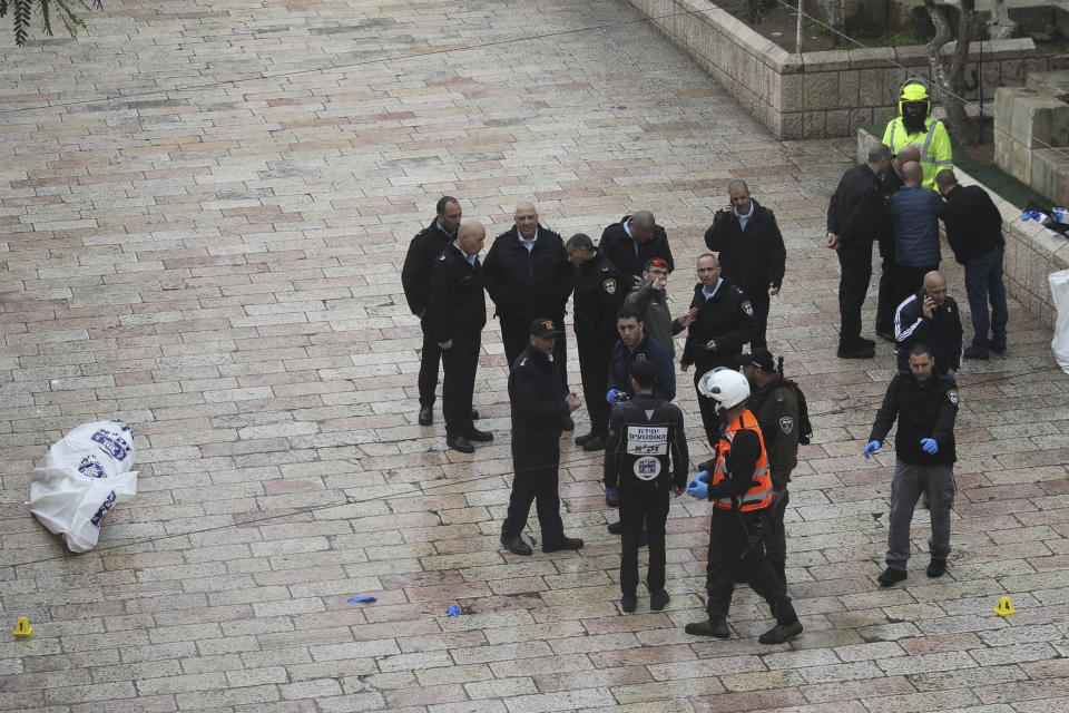 Israeli police stand next to a body in Jerusalem's Old City, Saturday, Feb. 22, 2020. Israeli police said officers shot and killed a man on Saturday after he allegedly tried to carry out a stabbing attack on a soldier outside Jerusalem's Old City. The suspect was not immediately identified, but is believed to have been a Palestinian. (AP Photo/Mahmoud Illean)