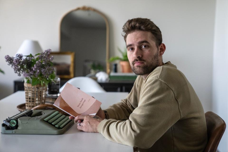 Will Bortz, a poet from Iowa, poses for a photo with his newly released book “Many Small Hungerings" at his home in Des Moines.