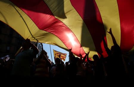 People hold up a giant Catalan separatist flag during a demonstration organised by Catalan pro-independence movements ANC (Catalan National Assembly) and Omnium Cutural, following the imprisonment of their two leaders Jordi Sanchez and Jordi Cuixart, in Barcelona, Spain October 21, 2017. REUTERS/Enrique Calvo