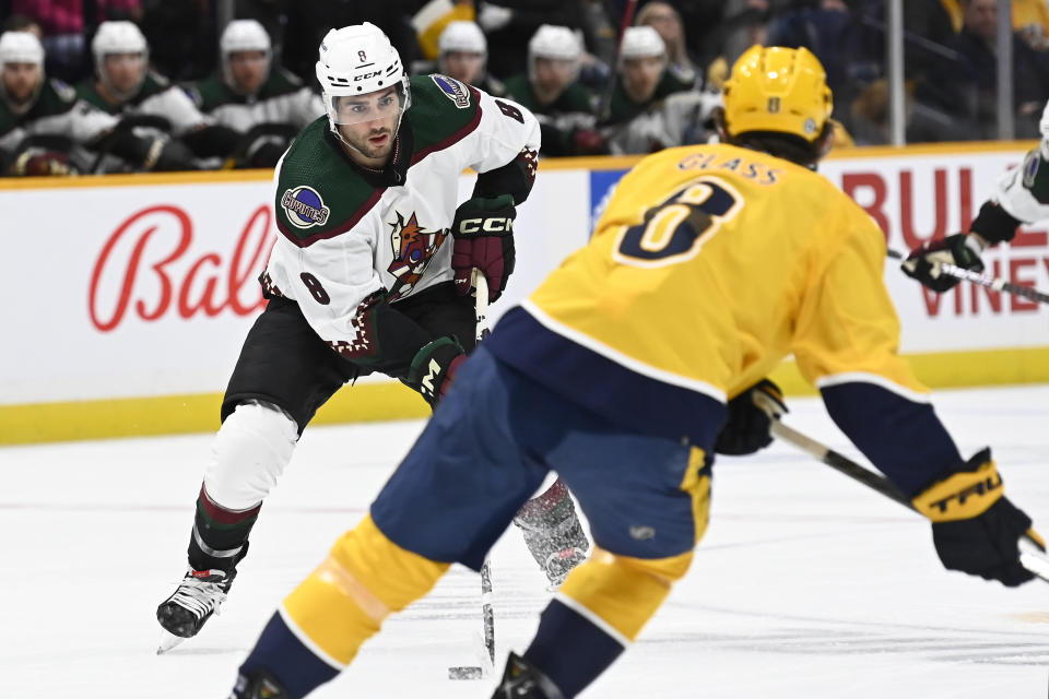 Arizona Coyotes center Nick Schmaltz moves the puck in front of Nashville Predators center Cody Glass during the first period of an NHL hockey game, Monday, Feb.13, 2023, in Nashville, Tenn. (AP Photo/Mark Zaleski)