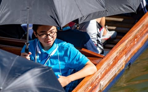 Punting on ther river Cam in Cambridge this morning with umbrellas up to keep off the sun - Credit: SWNS.com 