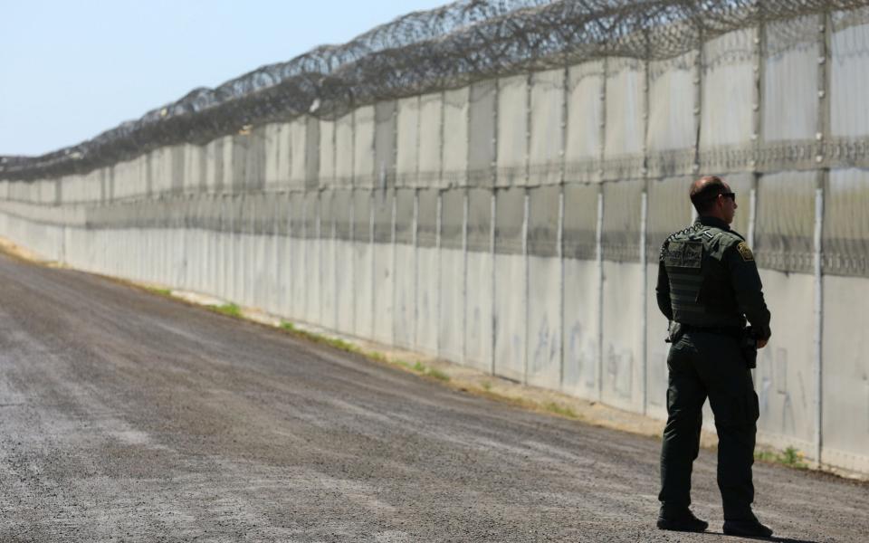 A U.S. Customs and Border Patrol officer stands along the secondary fence between the U.S. and Mexico in San Diego, California, U.S. April 21, 2017. - Credit: Mike Blake/Reuters