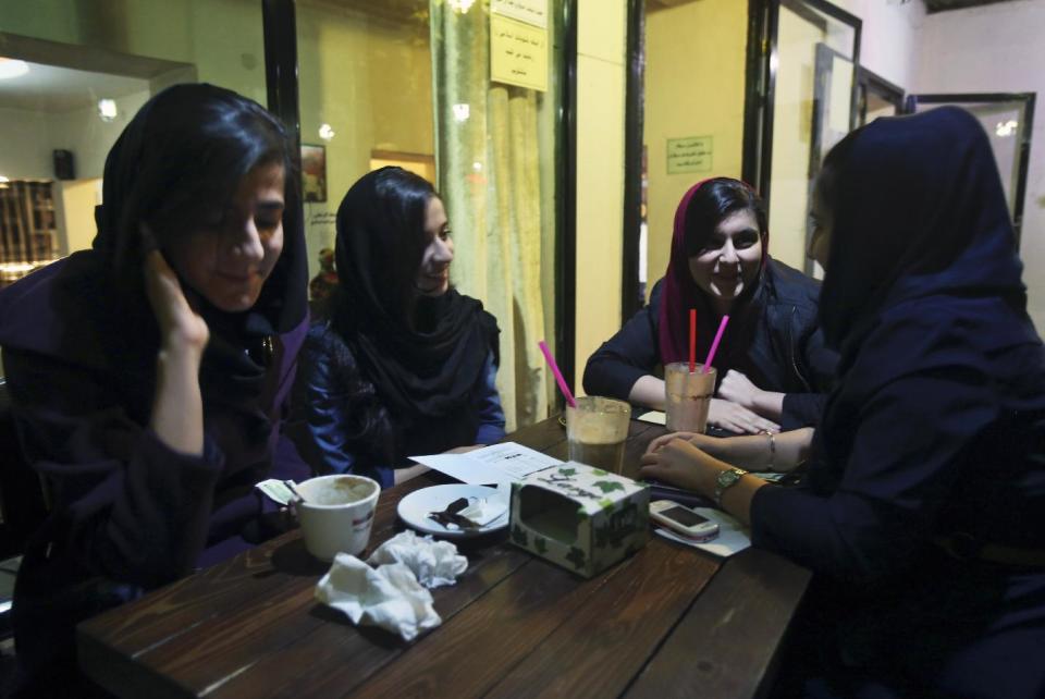 In this Tuesday, March 4, 2014 photo, young Iranian ladies meet at a cafe in Tehran, Iran. The number of cafes started to increase in 2011, two years after the controversial re-election of former President Mahmoud Ahmadinejad that led to a massive crackdown on opposition activists. (AP Photo/Vahid Salemi)