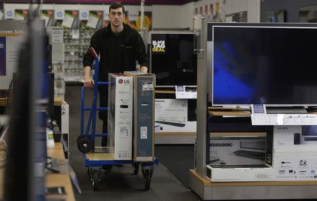 A worker pushes a trolley with retail goods for a customer on Black Friday at a store in Croydon, south London, Britain, November 25, 2016. REUTERS/Hannah McKay