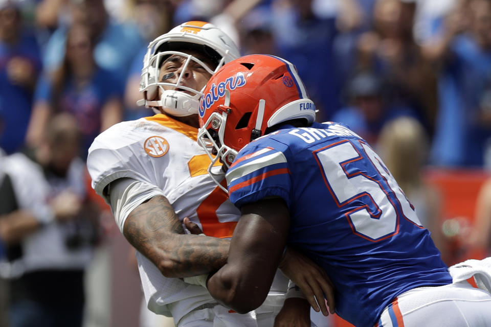 Tennessee quarterback Jarrett Guarantano, left, takes a hit from Florida linebacker Jonathan Greenard after throwing a pass during the first half of an NCAA college football game, Saturday, Sept. 21, 2019, in Gainesville, Fla. (AP Photo/John Raoux)