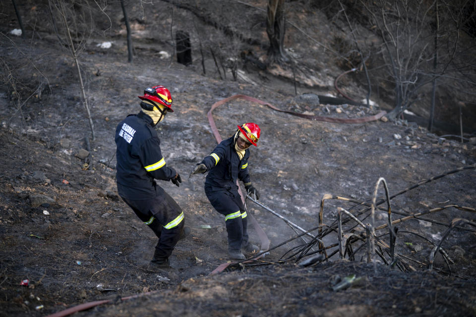 Firemen work at the University of Cape Town Campus in Cape Town, Monday April 19, 2021. People were evacuated from Cape Town neighborhoods as a raging wildfire sweeping across the slopes of the city’s famed Table Mountain was fanned by high winds and threatened homes. City authorities said the fire, which started early Sunday, was still not under control. The blaze has already burned the library and other buildings on the campus of the University of Cape Town. (AP Photo/Jerome Delay)