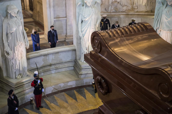 French President Emmanuel Macron and his wife Brigitte Macron stand by the tomb of Napoleon Bonaparte during a ceremony to commemorate the 200th anniversary of Napoleon Bonaparte's death, at the Invalides monument in Paris, Wednesday, May 5, 2021. French President Emmanuel Macron is leading commemorations of the bicentenary of the death of Napoleon Bonaparte on May 5, 1821 on the remote island of St. Helena, amid debate over the French emperor's legacy and role in reinstating slavery in French colonies. (Christophe Petit Tesson/Pool via AP)