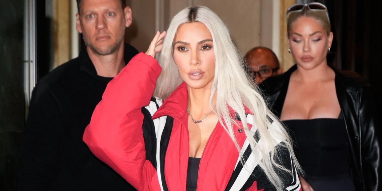 kim kardashian fixing her hair with her right hand as she walks through new york city