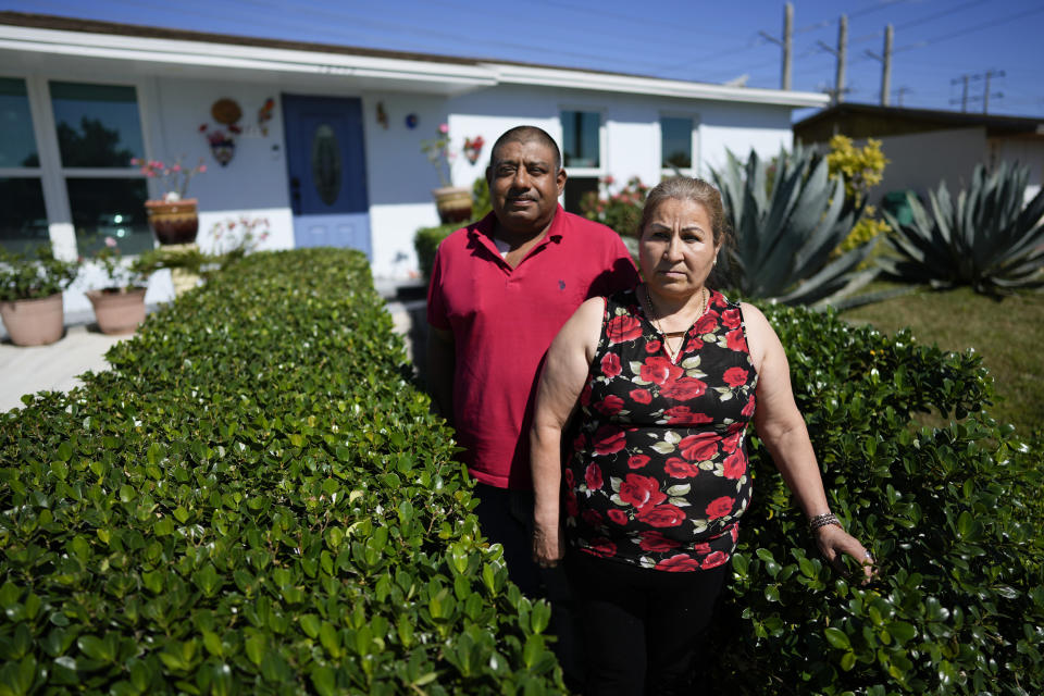 Rosalinda Ramirez, 57, and her partner Jose Guerrero, 41, Mexican immigrants who crossed the border separately over two decades ago and who have built lives and he a landscaping business in the U.S. but never found a route to obtain legal status, pose for a picture outside their home in Homestead, Fla., Tuesday, Nov. 7, 2023. The couple are among those longterm immigrants in the U.S. who are frustrated to see newer arrivals getting work permits and government assistance, while they have paid taxes for decades without earning work permits, the ability to visit relatives back home and return, or freedom from the fear of deportation. (AP Photo/Rebecca Blackwell)