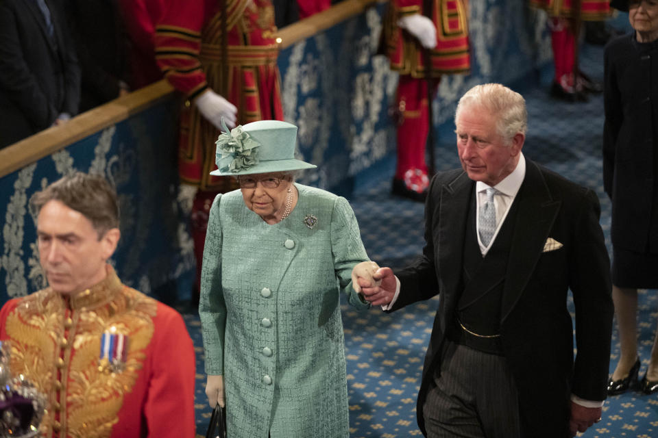 Britain's Queen Elizabeth II walks with Prince Charles through the Royal Gallery before delivering the Queen's Speech at the State Opening of Parliament ceremony at the Palace of Westminster and the Houses of Parliament in London, Thursday, Dec. 19, 2019. (AP Photo/Matt Dunham, Pool)