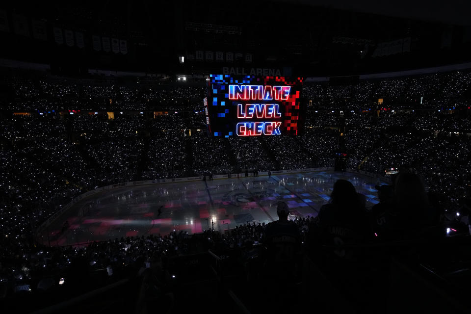 Fans watch a ceremony before Game 2 of the NHL hockey Stanley Cup Final between the Colorado Avalanche and the Tampa Bay Lightning, Saturday, June 18, 2022, in Denver. (AP Photo/David Zalubowski)