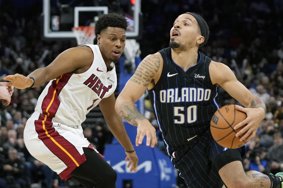 Orlando Magic guard Cole Anthony (50) drives around Miami Heat guard Kyle Lowry, left, during the second half of an NBA basketball game Sunday, Jan. 21, 2024, in Orlando, Fla. (AP Photo/John Raoux)