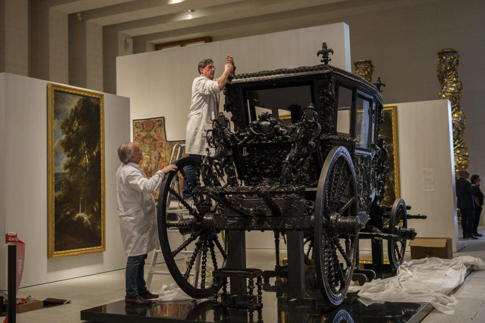 Staff members set up a Royal carriage at the Royal Collections Gallery in Madrid, Spain, Friday, May. 19, 2023. Spain is set to unveil what is touted as one of Europe’s cultural highlights of the year with the opening in Madrid of The Royal Collections Gallery next month. There will be works by Velázquez, Goya, Caravaggio, Titian and Tintoretto. Alongside are samples from possibly the world's best tapestries collection, as well as ancient carriages and jewels of royal furniture. (AP Photo/Manu Fernandez)