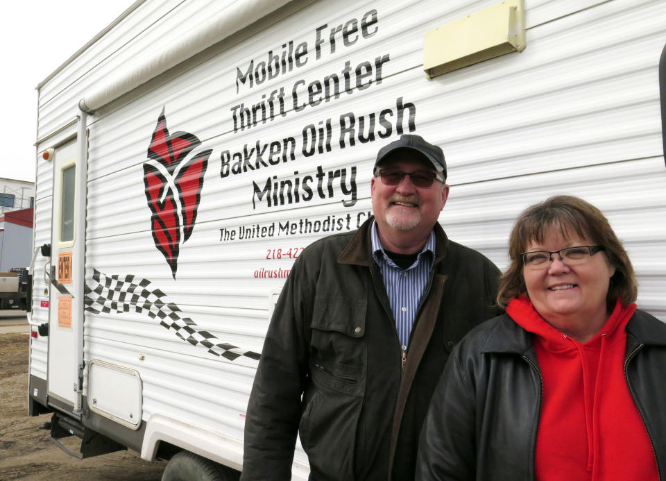 In this March 26, 2014 photo, James and Kathy Konsor, who head the Bakken Oil Rush Ministry, named after the formation that lies beneath northwestern part of the state, stand for a photo in Williston, N.D. The missionary couple use a camper emblazoned with the group's logo distribute clothes, blankets and household items to help the underprivileged who have moved to the oil patch that are at times unaware of the harsh weather conditions, the lack of housing and high cost of living. (AP Photo/Josh Wood)