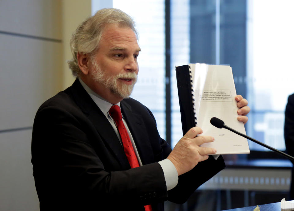 Attorney Randy Mastro holds up a copy of his report during a news conference Thursday, March 27, 2014, in New York. Mastro, with the law firm hired by New Jersey Gov. Chris Christie, said Thursday that the governor was not involved in a plot to create gridlock near a major bridge as part of a political retribution scheme. (AP Photo/Richard Drew)