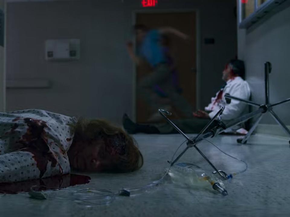 two dead bodies slumped over on a hospital floor, they're bloody and unmoving in stranger things