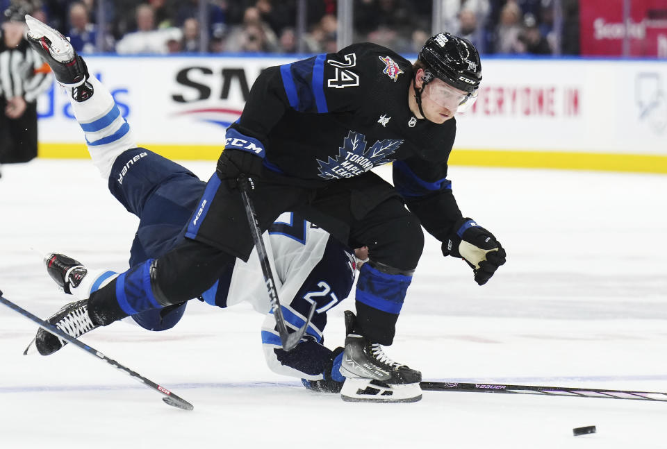 Winnipeg Jets forward Nikolaj Ehlers (27) trips as he chases Toronto Maple Leafs forward Bobby McMann (74) during the second period of an NHL hockey game Wednesday, Jan. 24, 2024, in Toronto. (Nathan Denvette/The Canadian Press via AP)
