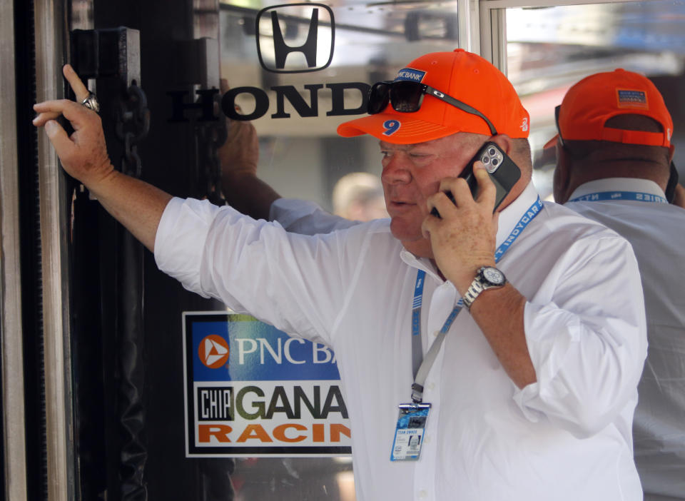 Car owner Chip Ganassi talks on his phone in the paddock before an IndyCar race at Mid-Ohio Sports Car Course in Lexington, Ohio, Sunday, July 4, 2021. (AP Photo/Tom E. Puskar)