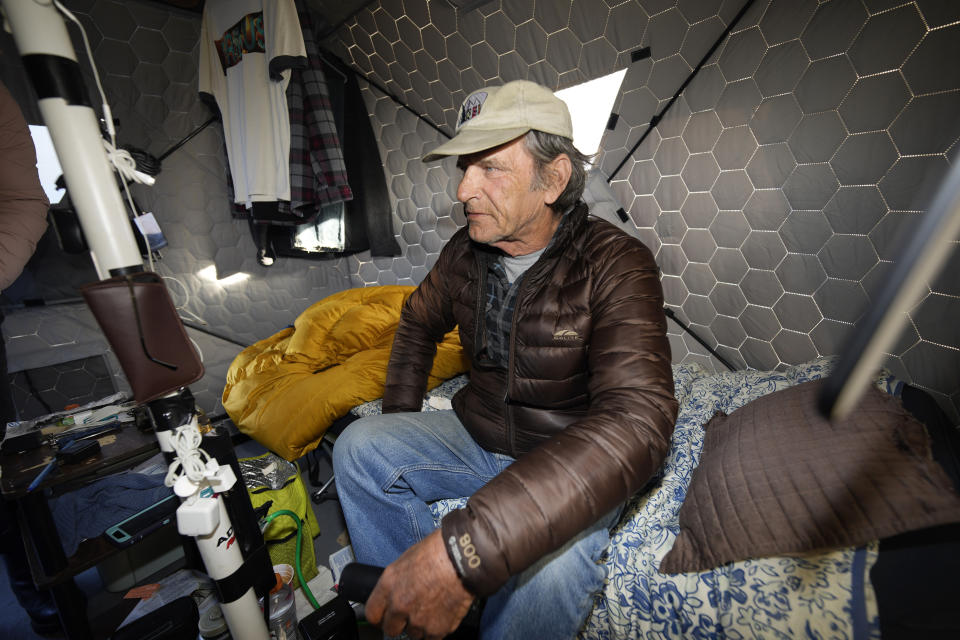 Gary Peters takes a rest in his tent at the east safe outdoor space in the parking lot of the city of Denver Human Service building in Denver on Thursday, Feb. 17, 2022. The safe space is home to more than 150 people. (AP Photo/David Zalubowski)