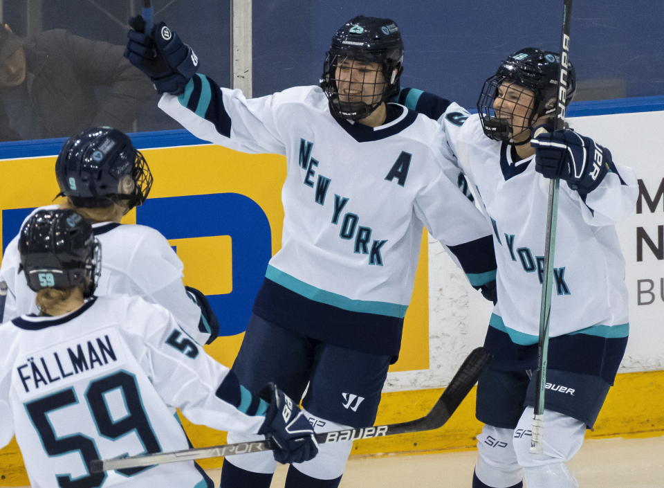 New York forward Alex Carpenter (25) is congratulated by teammates Paetyn Levis (19), Jade Downie-Landry (9) and Johanna Fallman after scoring against Toronto during the third period of a PWHL hockey game in Toronto, Ontario, Monday, Jan. 1, 2024. (Frank Gunn/The Canadian Press via AP)
