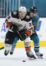 Anaheim Ducks left wing Andrew Agozzino (26) and San Jose Sharks left wing Marcus Sorensen (20) vie for the puck during the second period of an NHL hockey game, Monday, April 12, 2021, in San Jose, Calif. (AP Photo/Tony Avelar)