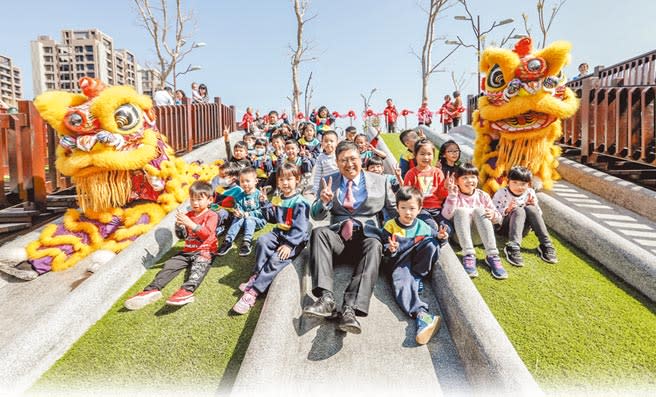 竹東台泥公園熱鬧啟用，縣長楊文科和小朋友在溜滑梯快樂合影。（羅浚濱攝）