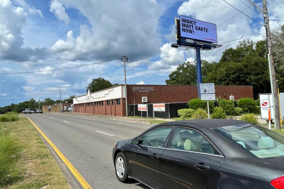 An eastbound motorist on John Sims Parkway in Valparaiso drives past an electronic billboard reading "Indict Matt Gaetz Now!"