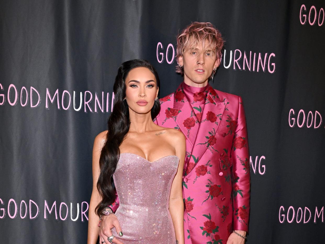 Megan Fox in a metallic pink dress and Machine Gun Kelly in a floral pink suit on the red carpet