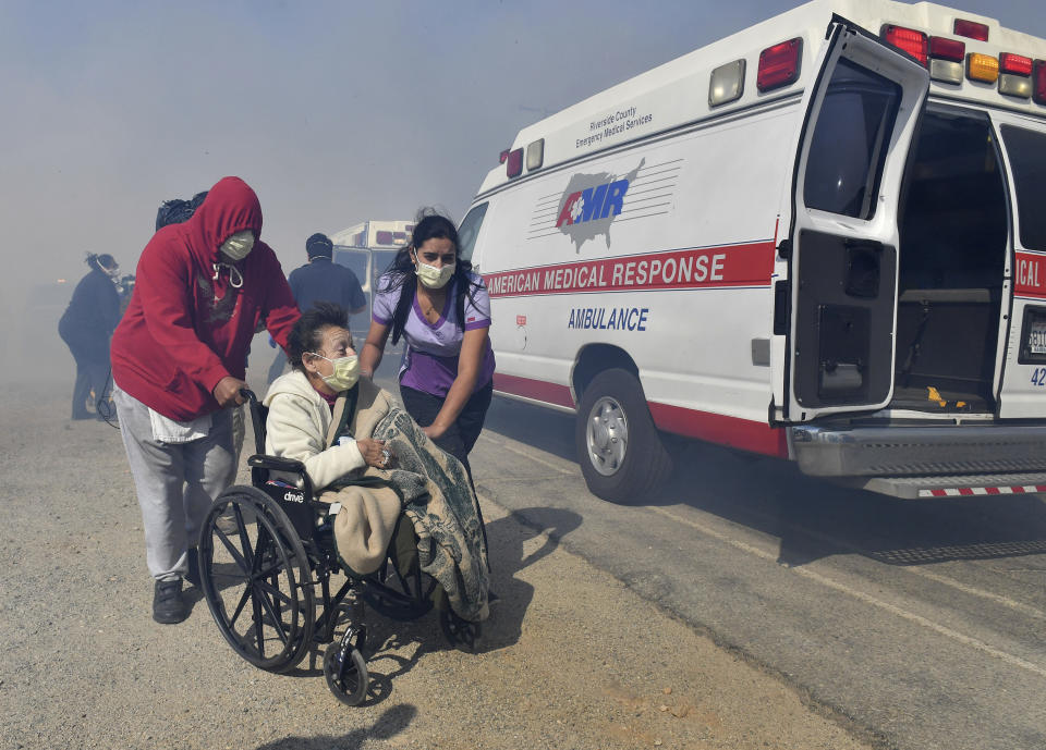 Elderly residents of the Riverside Heights Healthcare Center in Jurupa Valley, Calif., are evacuated from their care facility as flames and smoke from the Hill Fire approach Wednesday Oct 30, 2019. (Will Lester/The Orange County Register via AP)