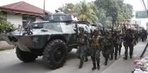 Members of the elite Special Action Police walk next to an armoured vehicle as they reinforce soldiers battling Muslim rebels from the Moro National Liberation Front (MNLF) in Zamboanga city, in southern Philippines, September 12, 2013. Fighting between security forces and the rogue Muslim rebels seeking to declare an independent state escalated in Zamboanga city on Thursday and spread to a second island, officials said. U.S.-trained commandos exchanged gunfire with a breakaway faction of the MNLF holding dozens of hostages in Zamboanga City, on the southernmost island of Mindanao, army spokesman Domingo Tutaan said. REUTERS/Erik De Castro (PHILIPPINES - Tags: CIVIL UNREST CONFLICT POLITICS)