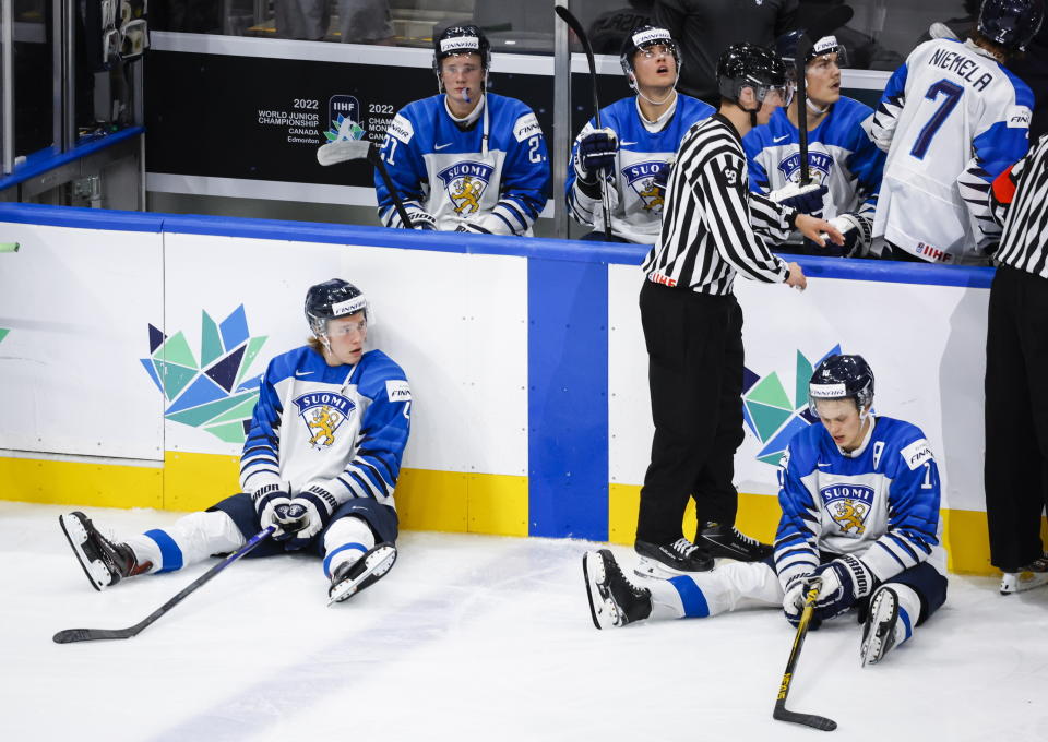 Finland defensemen Joni Jurmo, left, and Kasper Puutio react after losing to Canada during overtime IIHF world junior hockey championship gold medal game action in Edmonton, Alberta, Saturday, Aug. 20, 2022. (Jeff McIntosh/The Canadian Press via AP)
