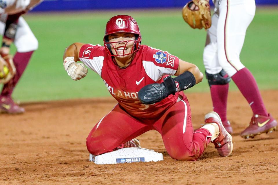 Oklahoma utility Alyssa Brito (33) celebrates after sliding to second base in the second inning during the first game of the Women's College World Series finals between Oklahoma (OU) and Florida State at USA Softball Hall of Fame Stadium in Oklahoma City on Wednesday, June 7, 2023.