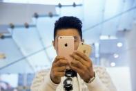 A man takes pictures as Apple iPhone 6s and 6s Plus go on sale at an Apple Store in Beijing, China September 25, 2015. REUTERS/Damir Sagolj